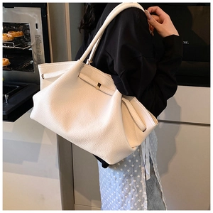 Detail showing the creamy beige leather texture and drawstring of the large tote bag