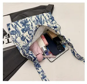 Spacious interior of embroidered canvas tote bag holding an iPad, phone and umbrella