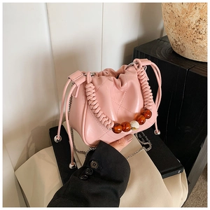 Pink pleated bucket bag with amber bead handle and silver metal chain strap detail