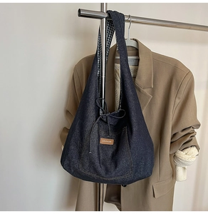 Détail du sac cabas en denim bleu avec nœud et logo jollyhouse sur blazer kaki