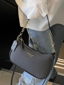 Sac baguette noir tissé minimaliste avec bandoulière chaîne dorée et logo chic