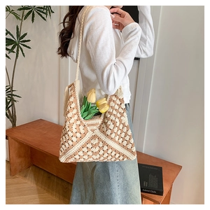 Detail of hand-woven crochet hobo bag with brown geometric patterns and fringe tassel