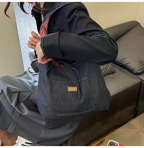 Détail du sac cabas en jean bleu avec patch en cuir jollyhouse et fermeture à cordon