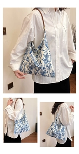 Close-up of canvas tote bag featuring blue floral embroidery and brown leather strap