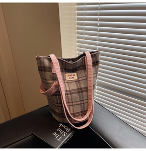 Detail of tweed checkered tote bag with pink canvas straps and magnetic buckle closure