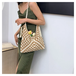 Detail of bohemian hand-woven tote bag with geometric diamond patterns and long tassels