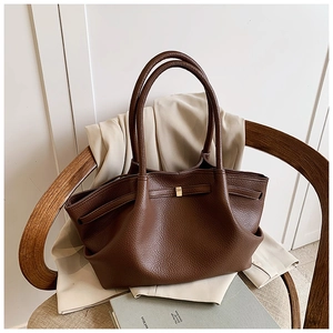 Detailed close-up of dark brown lychee pattern leather tote bag on wooden chair