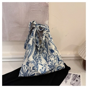 Detail of canvas tote bag featuring vintage blue floral embroidery and unique origami shape