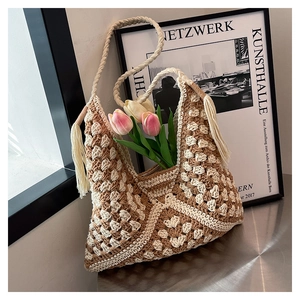 Detailed close-up of handmade woven tote bag with fringe tassels and crochet patterns