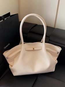 Minimalist beige leather tote bag with pleated texture and golden buckle detail