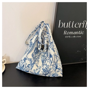 Detailed texture of blue floral canvas tote bag showing soft fabric and dual handles