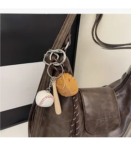 Detail of baseball theme charm with bat and glove on a vintage brown tote bag