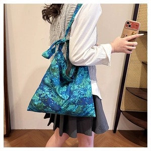 Detailed view of floral pattern embroidery on a blue lightweight canvas tote bag
