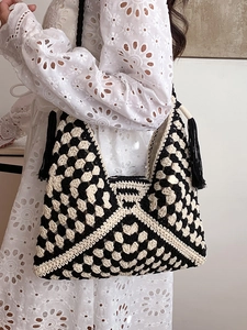 Handmade crochet tote bag with black and white checkerboard pattern and boho tassels