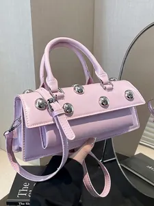 Sac baguette en cuir rose brillant avec gros rivets argentés et bandoulière chic