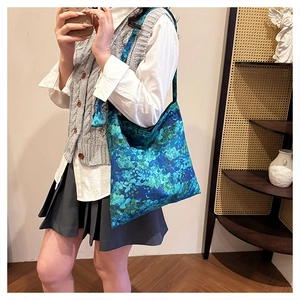 Close-up of floral embroidery on a large teal canvas tote bag for casual daily use