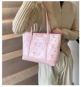 Detailaufnahme der rosa Tragetasche mit Cartoon-Prints und Markenlogo aus Metall