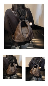 Macro shot of a vintage dark brown PU leather tote bag with a unique baseball charm detail