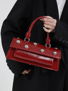 Sac baguette en cuir verni rouge foncé avec rivets argentés et poignée élégante