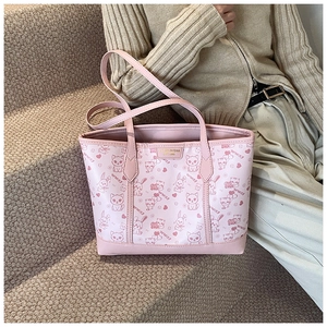 Detailaufnahme der rosa Tragetasche mit süßen Tiermustern und edler Marken-Metallplakette