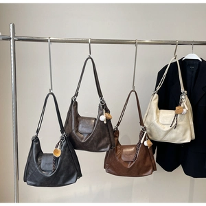Detail view of retro soft leather tote bags in four colors with decorative baseball charms