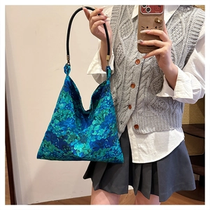 Detail of blue floral tote bag with black round handle and vintage metal hardware