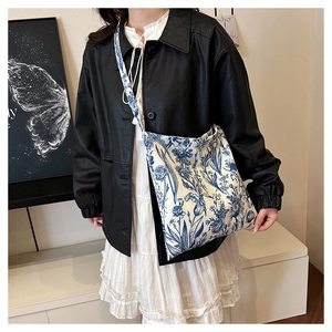 Detail of floral canvas tote bag with retro blue pattern and matching shoulder strap