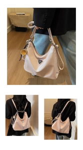 Detail der rosa glänzenden Oil-Wax Leder-Tasche mit Trägern und Metall-Logo-Plakette