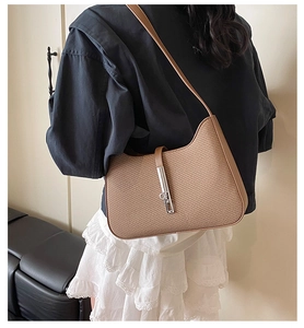 Detailed view of brown woven hobo bag with classic silver piston lock and leather strap