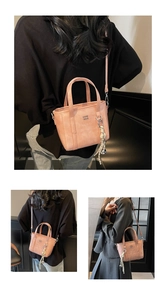Close-up of pink textured bucket bag with metal logo and woven charm detail