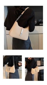 Detail showing beige woven texture and silver piston clasp on a hobo shoulder bag