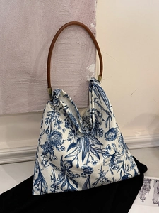 Artistic canvas tote bag with blue vintage floral patterns and a round wooden handle