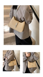 Detail of woven texture beige shoulder bag with metal buckle and chain strap