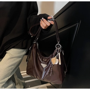 Detail der dunkelbraunen Hobo-Tasche aus Wachsleder mit Glanz-Finish und silbernem Logo
