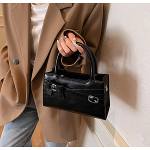 Black high-gloss square bag featuring silver buckle details and rounded handle design