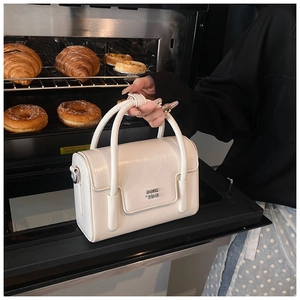 Detail of white PU leather square bag with COIH metal logo and textured finish