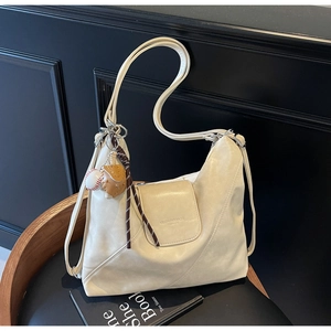 Detail of off-white Hobo tote bag with a trendy baseball glove charm accessory