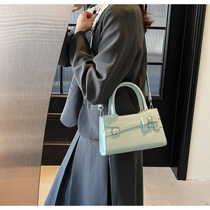 Detail of mint green matte leather handbag with silver buckle and detachable shoulder strap