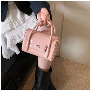 Detail of pink glossy oil wax leather handbag with double handles and metal logo