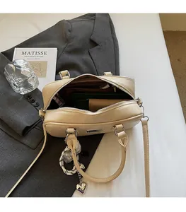 Detail view of cream Boston bag interior capacity showing phone and wallet storage