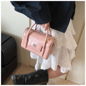 Pink vintage glossy patent leather square handbag showing handheld size and style