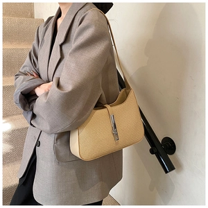 Detailed macro view of woven shoulder bag featuring a silver metal buckle and leather trim