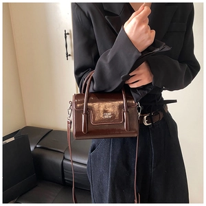 Detail view of the polished dark brown oil wax leather bag with the COIH 2DN embossed text