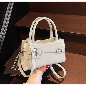 Detail view of the mint green handbag with decorative bow and silver metal buckles