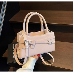 Detail of pink leather handbag showing ribbon bow and metallic silver hardware accents