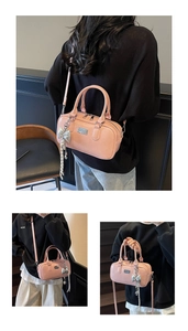 Detailed view of pink PU leather bowling bag with silver bow charm and adjustable strap