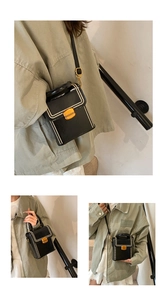 Close-up of black box bag with white bead trim and golden metal buckle details