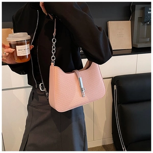 Detail of pink hobo bag with woven texture, metal buckle, and chain strap for women