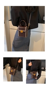 Detail of a vintage dark brown leather box bag with contrast stitching and metal buckle