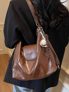 Vintage brown soft leather tote bag with baseball pendant charm and wide shoulder strap